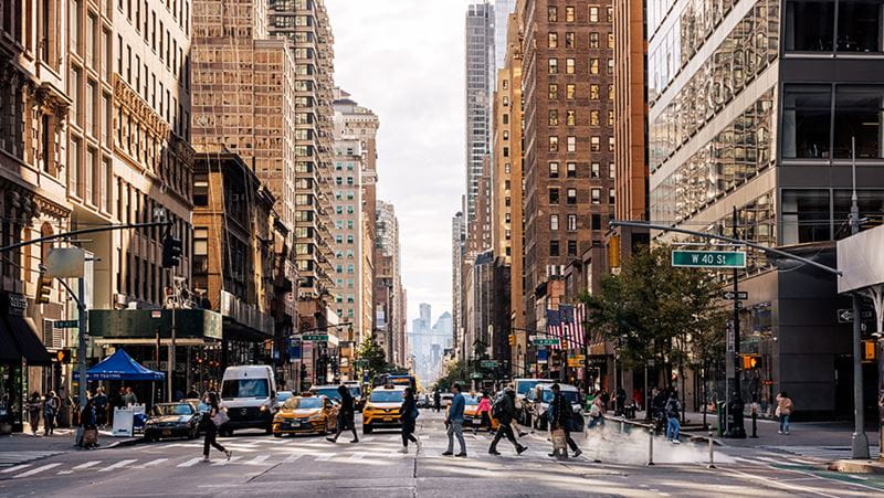 People crossing a busy street in a downtown district of a large city